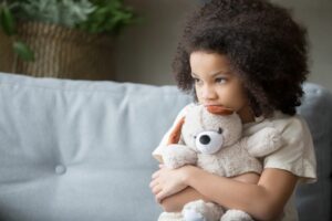 child with mental health disorder cuddling soft toy