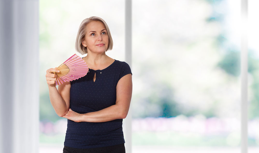 woman-holding-fan-hot-flush-perimenopause.jpg